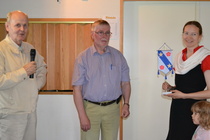 Rahastonhoitaja Meri Kokkola palkittiin sukuseuran hyväksi tehdystä työstä Taneli Koskelan suunnittelemalla viirillä.